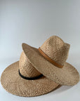 Stack of new Straw panama hats with leather bands, one tan on black.