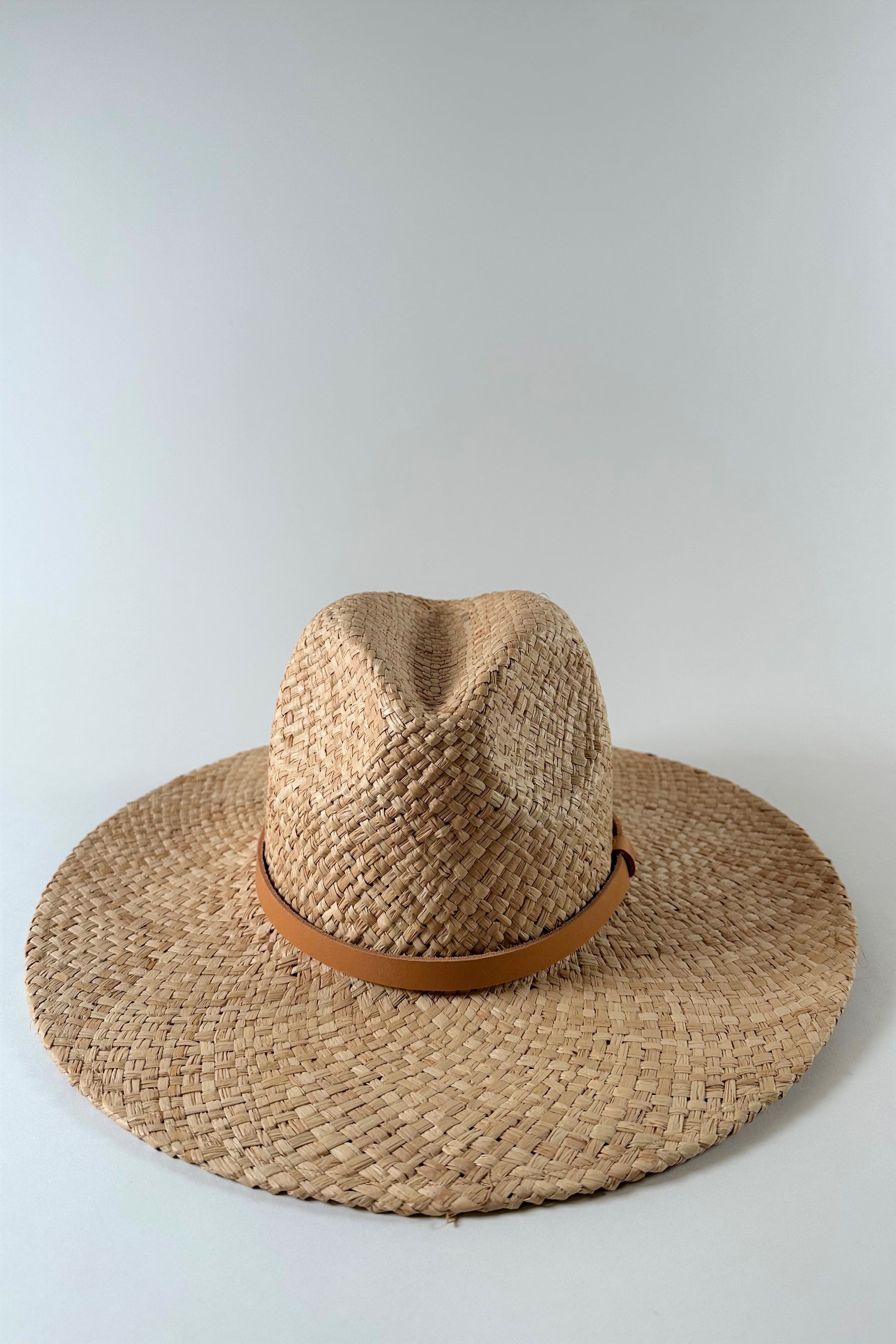 Straw panama hat with a tan leather band. 