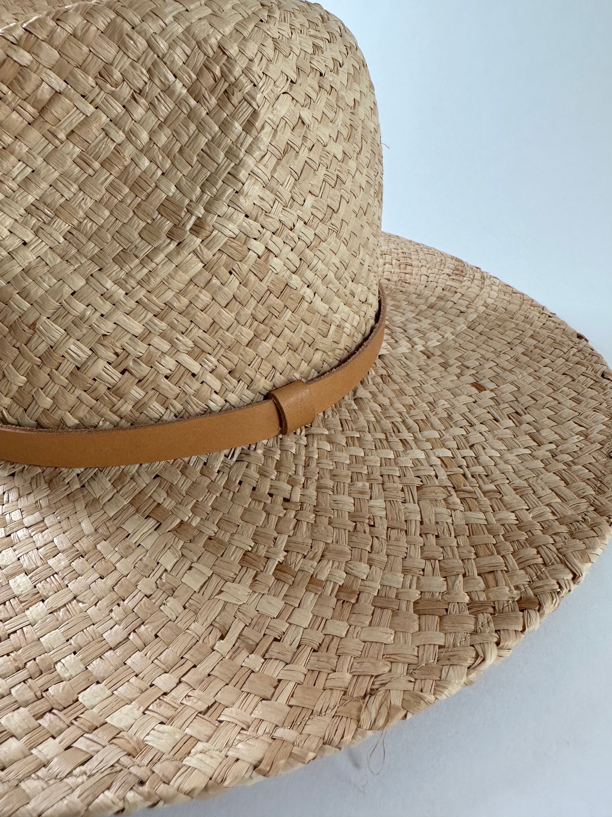 Close up of Straw panama hat with a tan leather band. 