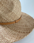 Close up of Straw panama hat with a tan leather band.