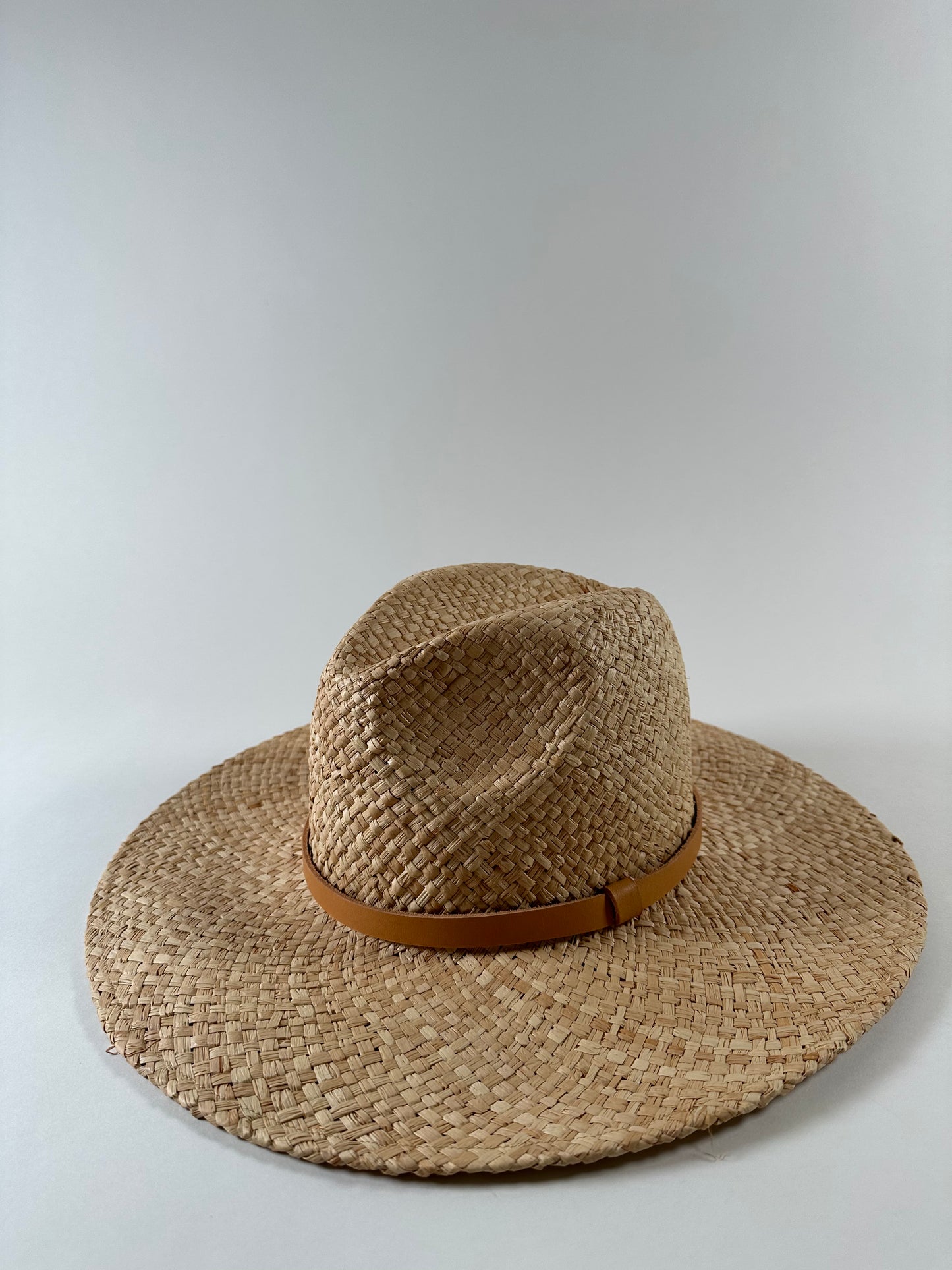 Straw panama hat with a tan leather band. 