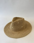 Brown straw hat with small white patterns on a light gray background