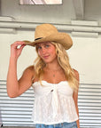 Person wearing the Raffie Straw Western Hat with black leather band