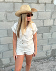 Person wearing the Raffie Straw Western Hat with black leather band