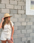 Person wearing straw panama hat with a tan leather band.