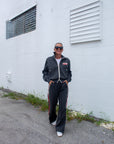 Person wearing a tracksuit standing in front of a white wall.