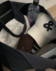 Close-up of a bag with a cream basehat, water bottle and sunglasses inside.