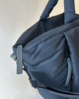 Close up of large puffy navy nylon tote bag with crossbody strap