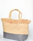 Natural raffia straw tote with linen lining and gray color block base.