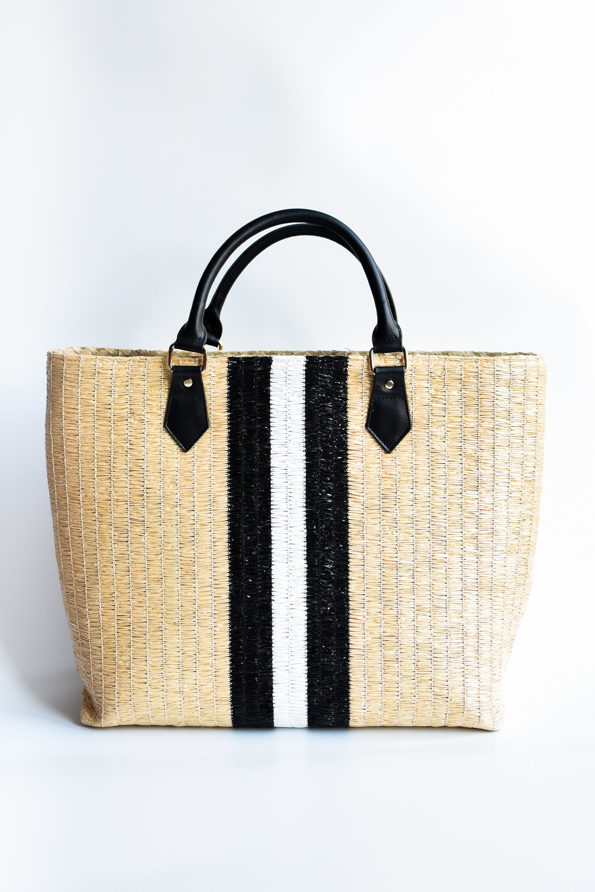 Benicia straw tote bag with black leather handles and black & white center stripe.