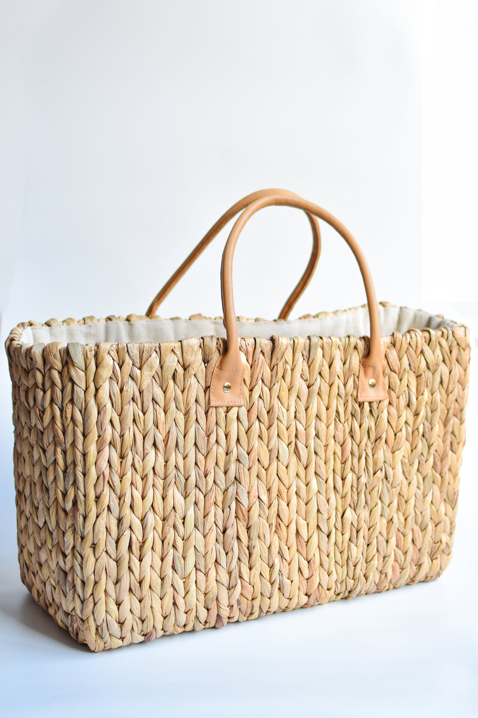 Extra large natural hyacinth straw tote with matching leather handles.