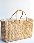 Extra large natural hyacinth straw tote with matching leather handles.