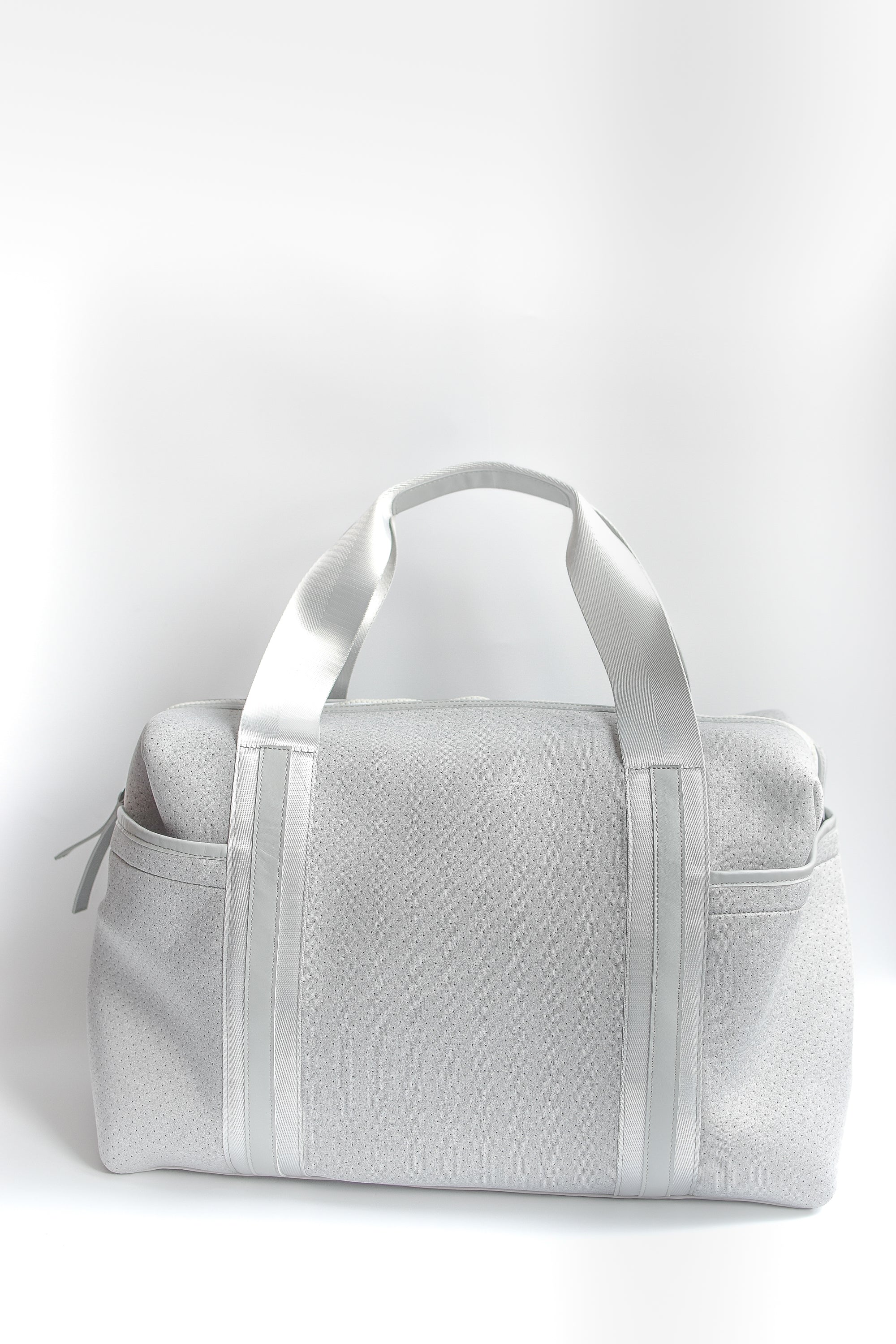 Callahan light gray perforated neoprene duffel bag with grey straps and leather details.