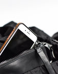 Interior leather pocket detail on black nylon convertible backpack tote with leather details.