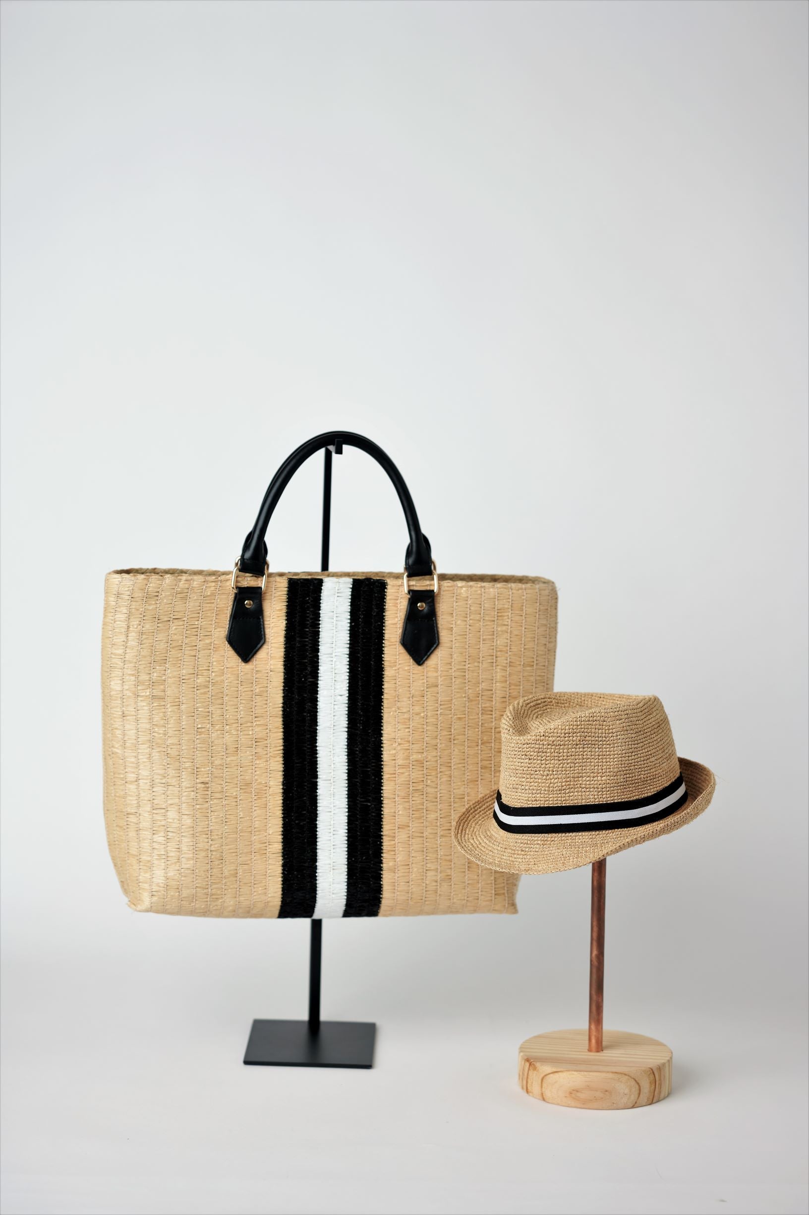 Collection of Anya & Niki Benicia straw tote bag with black leather handles and black & white center stripe, along with the Essential crochet straw hat with black and white band.