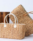 Collection of two Anya & Niki hyacinth straw tote bags with leather handles in a medium and large size.