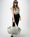 Person holding the Callahan light gray perforated neoprene duffel bag with leather details.
