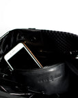 Close up of interior leather pocket on black sporty mesh and shiny vinyl tote bag.