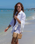 Person wearing the Hampton mini straw bag with white crossobdy strap with leather details