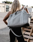 person holding the Callahan light gray perforated neoprene duffel bag over their back