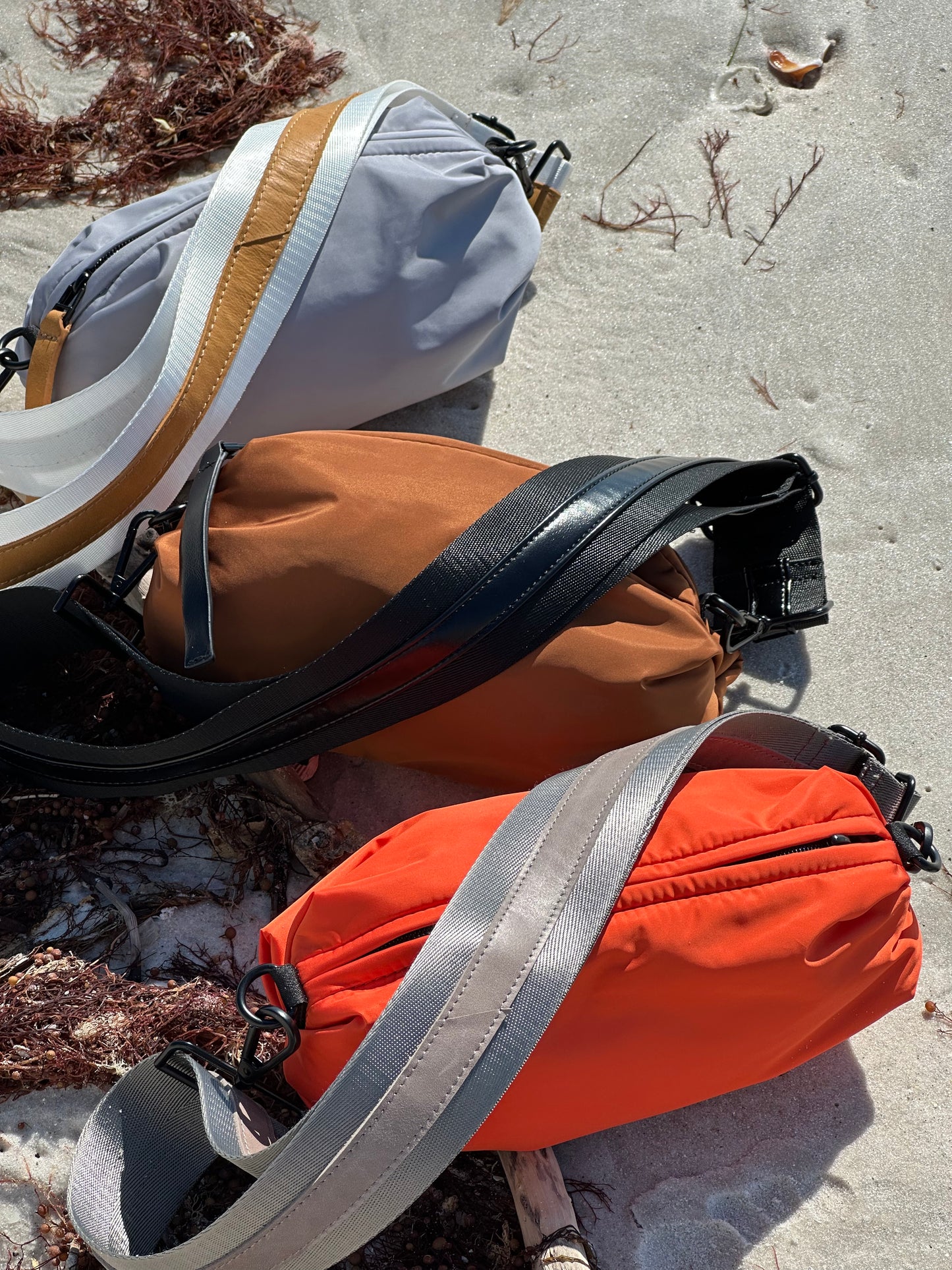 Collection of 3 Orlando Belt Bags in Gray, Brown and Orange on the beach