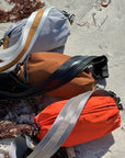 Collection of 3 Orlando Belt Bags in Gray, Brown and Orange on the beach