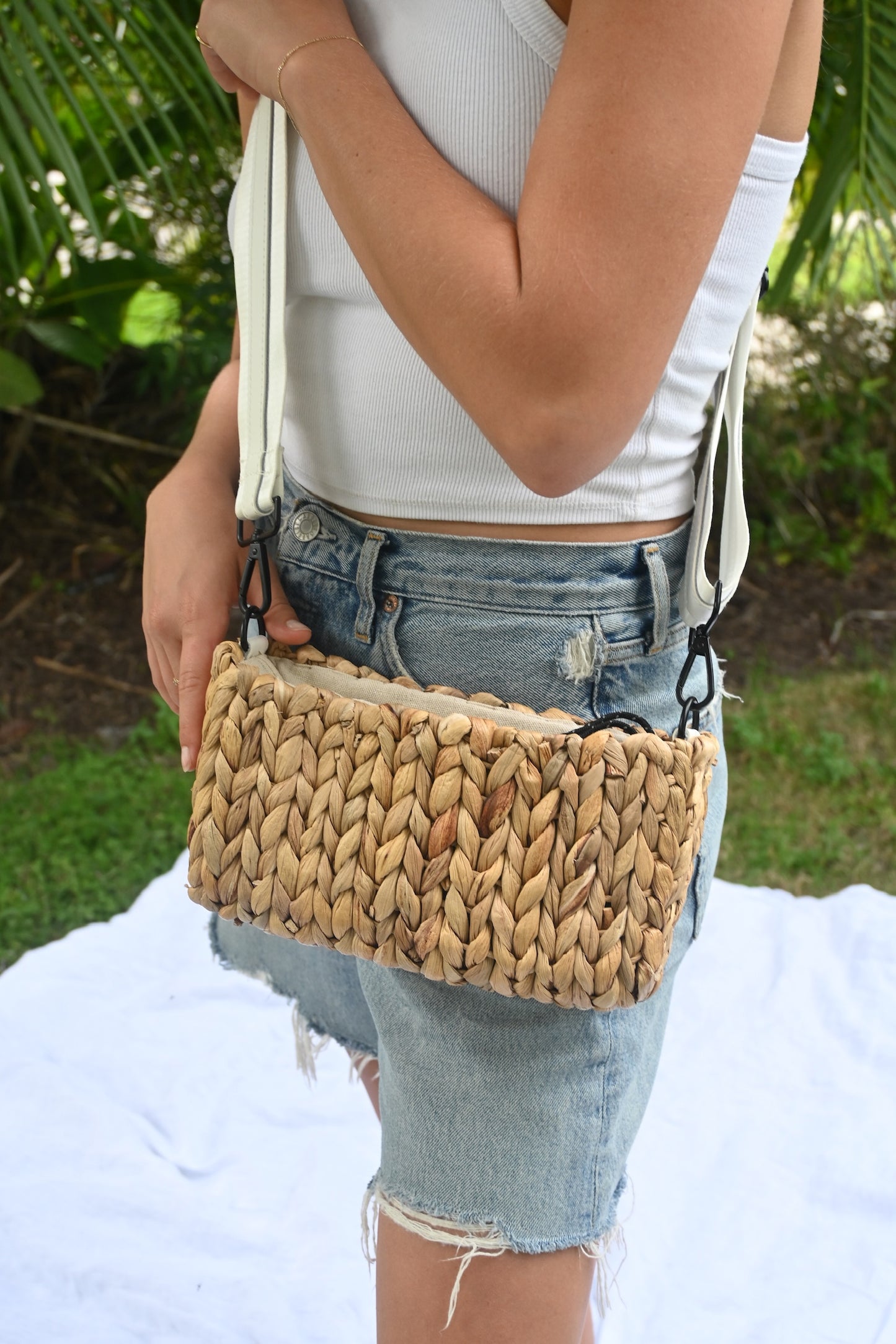 Person wearing the Hampton mini straw bag with white crossobdy strap with leather details