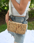 Person wearing the Hampton mini straw bag with white crossobdy strap with leather details