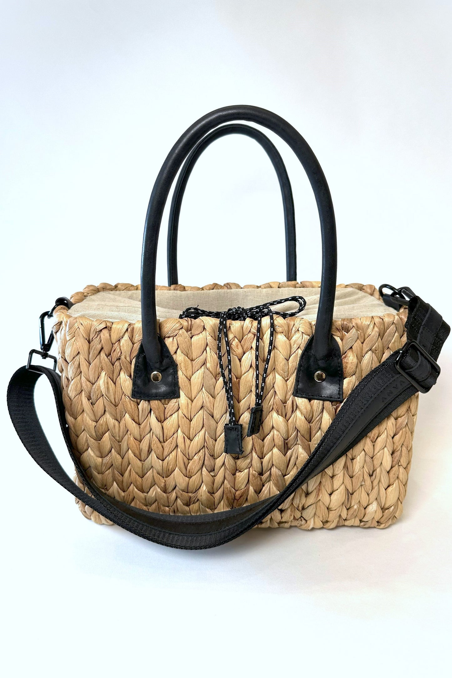 Medium sized hyancinth straw bag with black leather handles and black crossbody strap