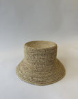 Woven straw bucket hat on a plain background
