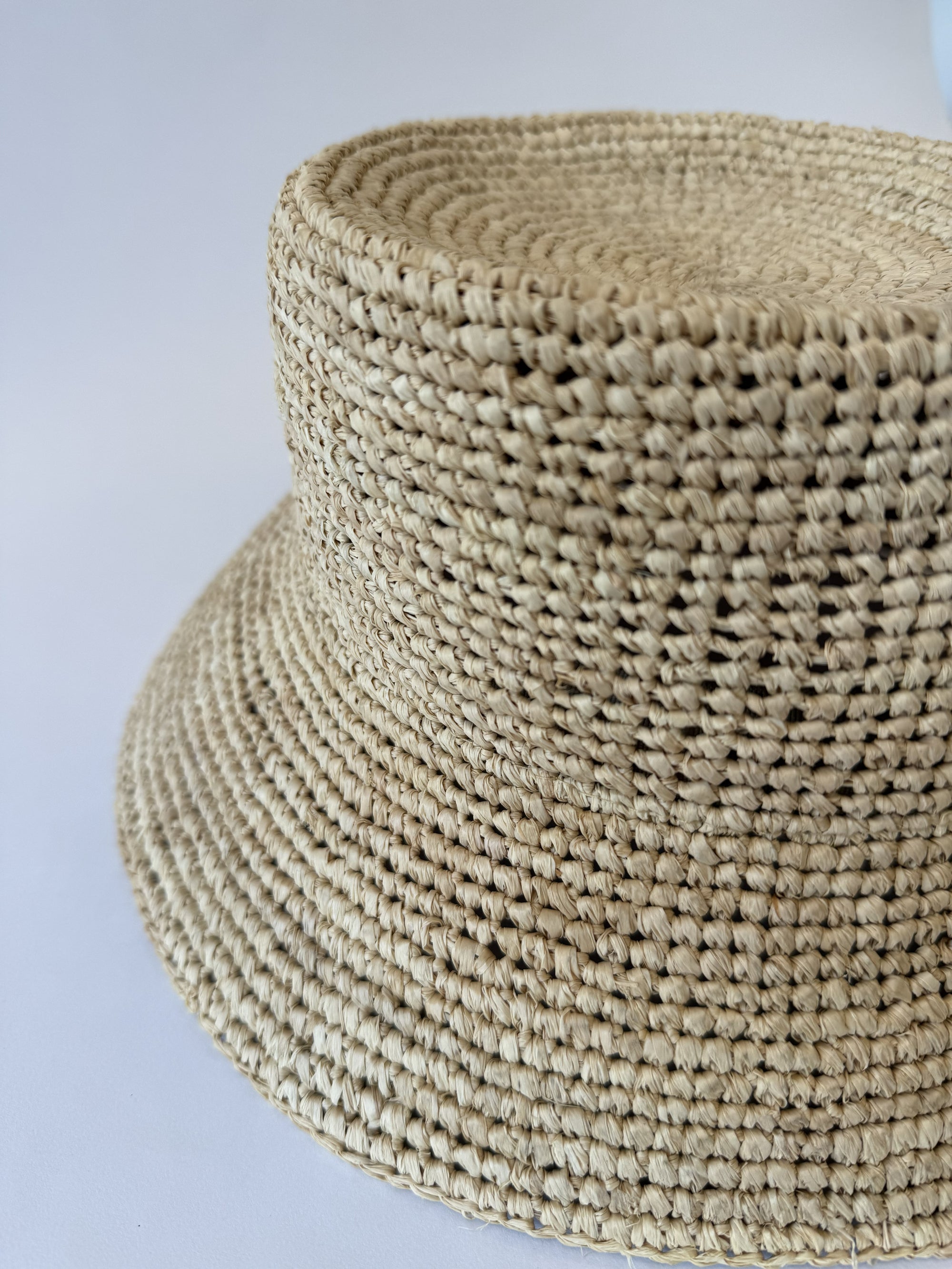 Close-up of a woven straw hat on a light gray background