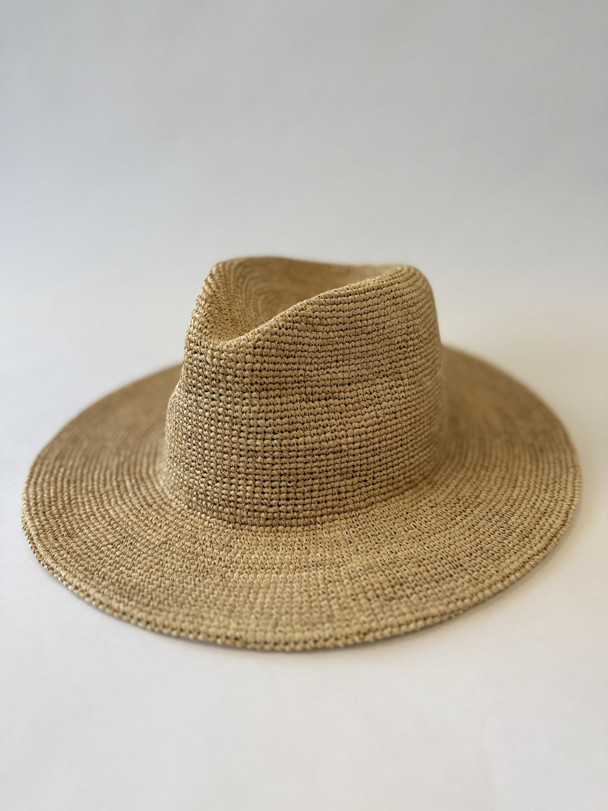Beige fedora straw hat on a white background