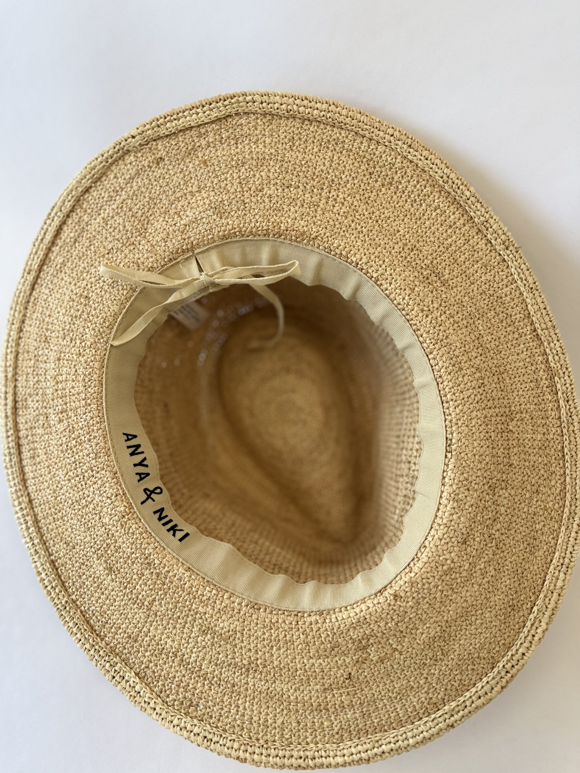 Inside of a straw fedora hat with adjustable band