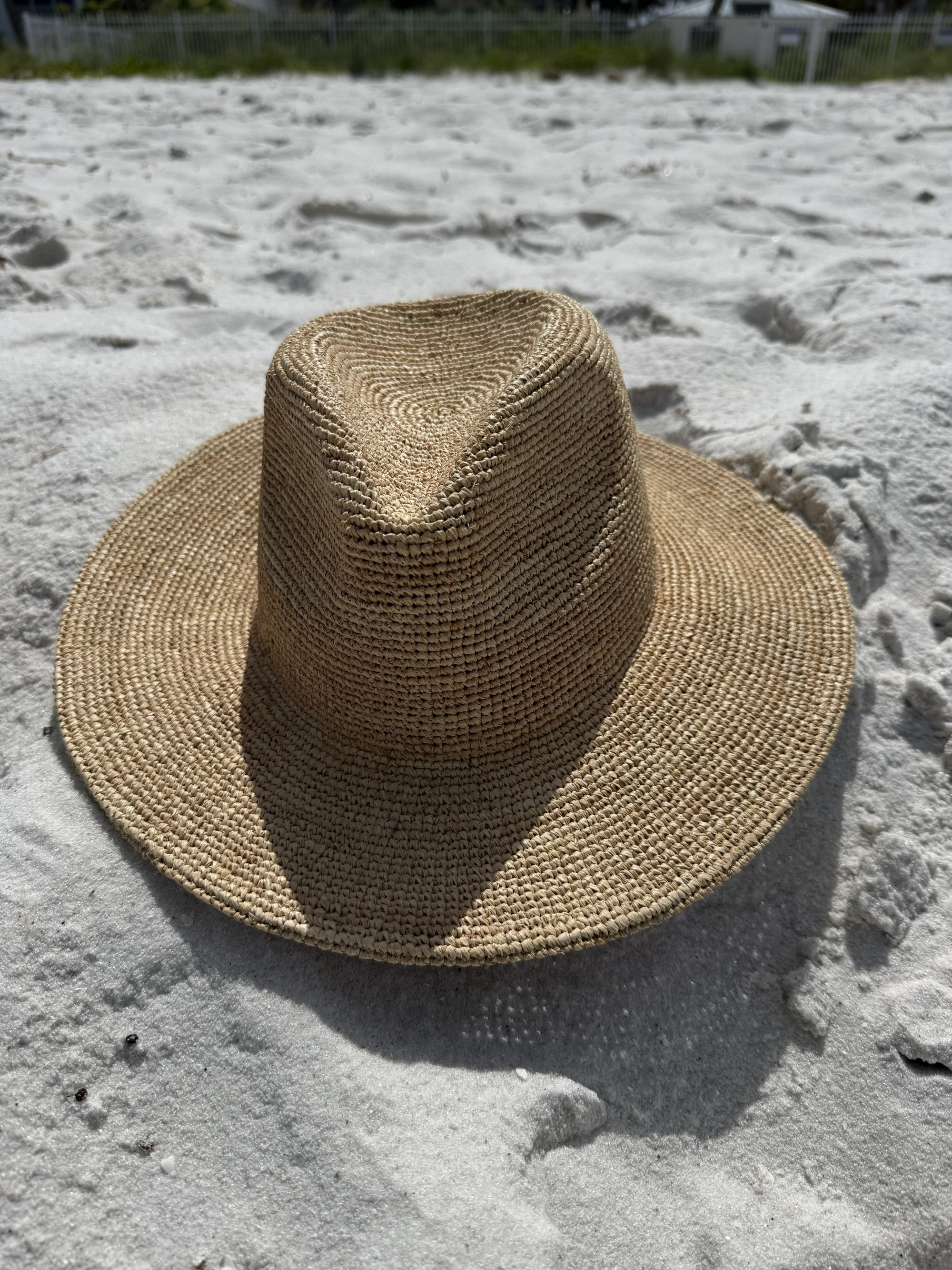 Straw fedora hat on a sandy beach