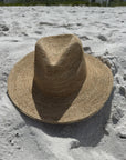 Straw fedora hat on a sandy beach