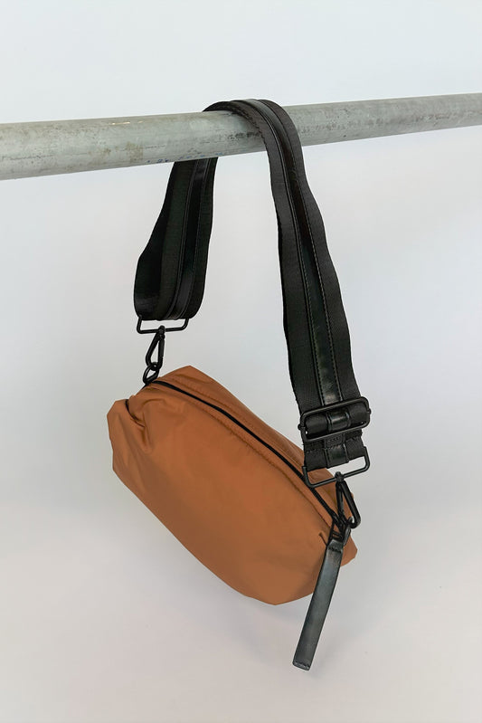 brown nylon belt bag with black crossbody strap and shiny black leather detail