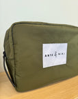 Green pouch with 'Anya & Niki' label on a wooden surface