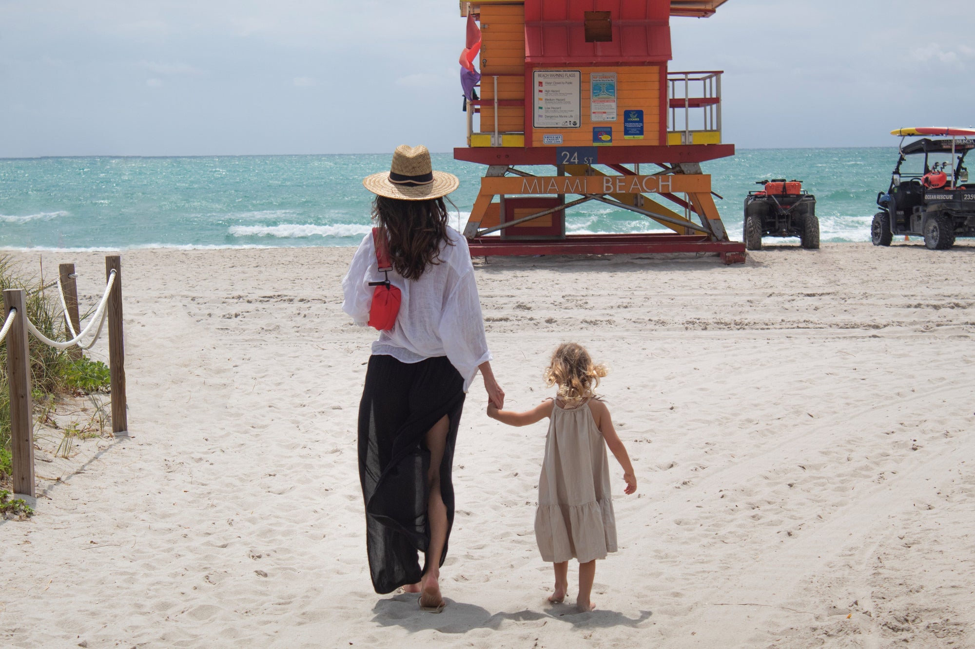 People at the beach wearing the Orlando Crossbody Belt Bag in Red