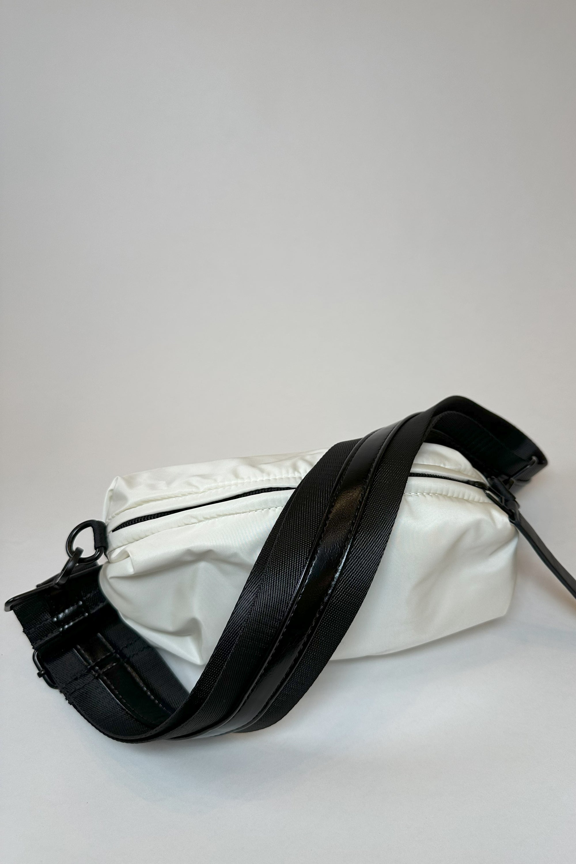 Cream nylon belt bag with black crossbody/belt bag strap with shiny black leather detail