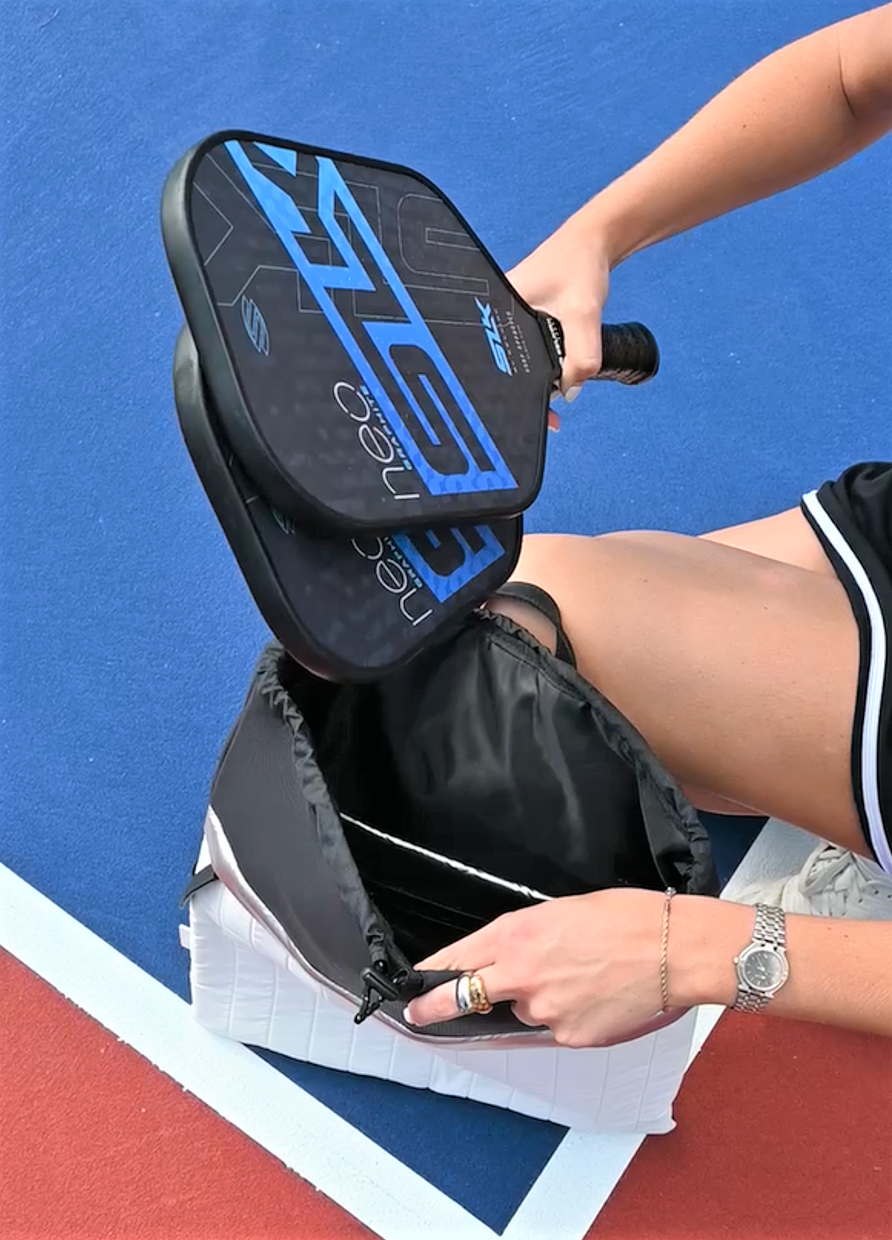 Person putting pickleball paddles into the Pace Backpack 