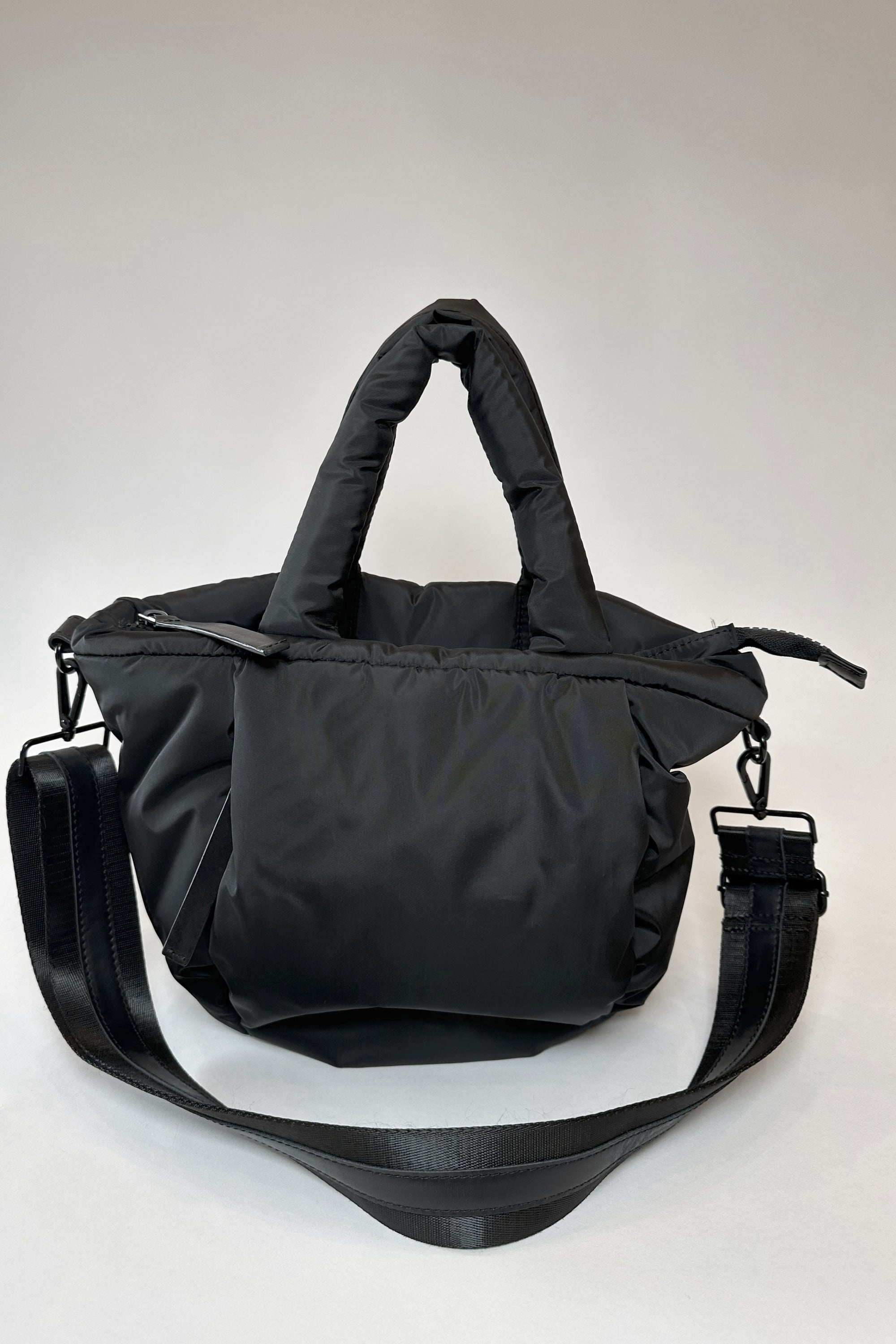 Mid-sized black nylon puffy tote with removable crossbody strap with leather detail