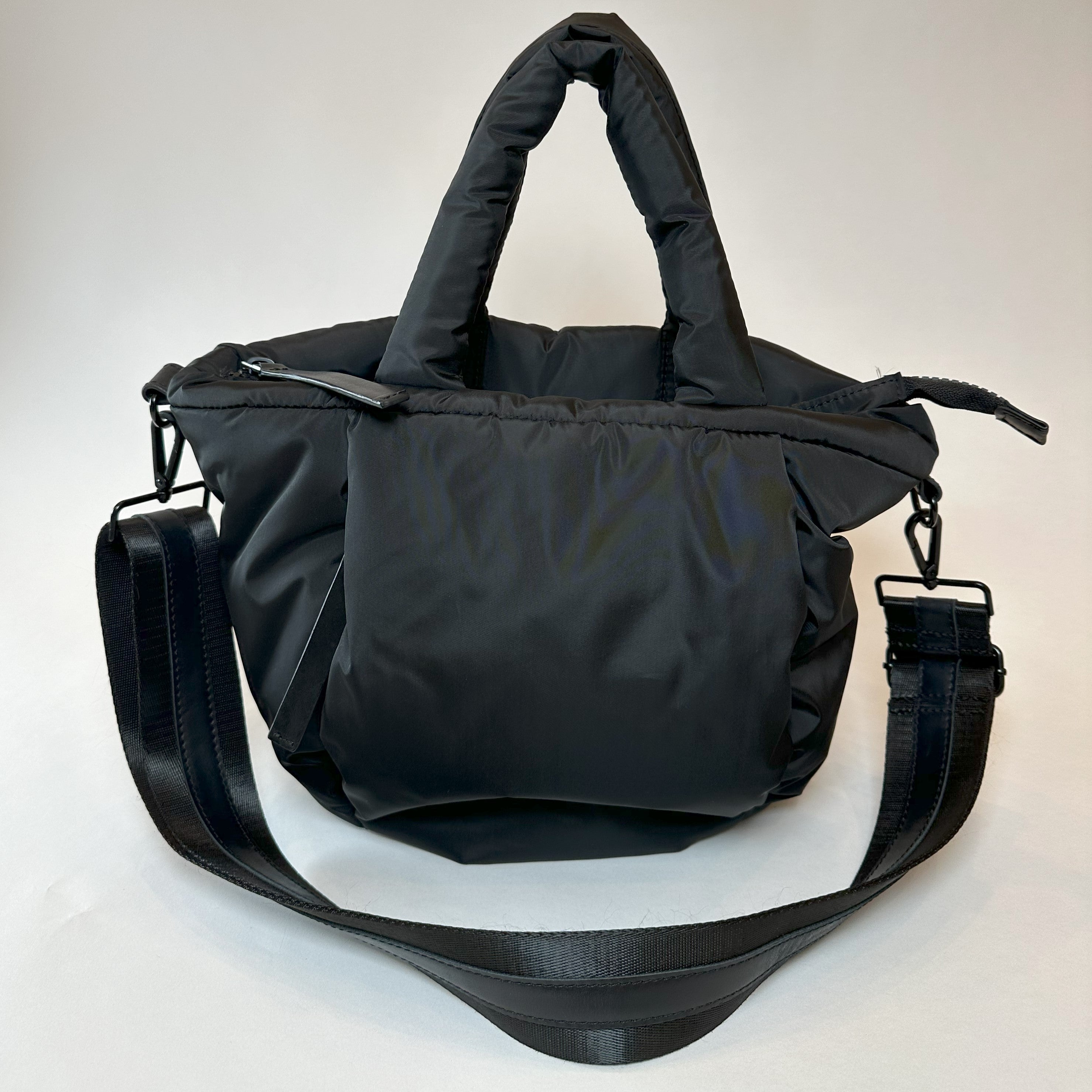 Mid-sized black nylon puffy tote with removable crossbody strap with leather detail