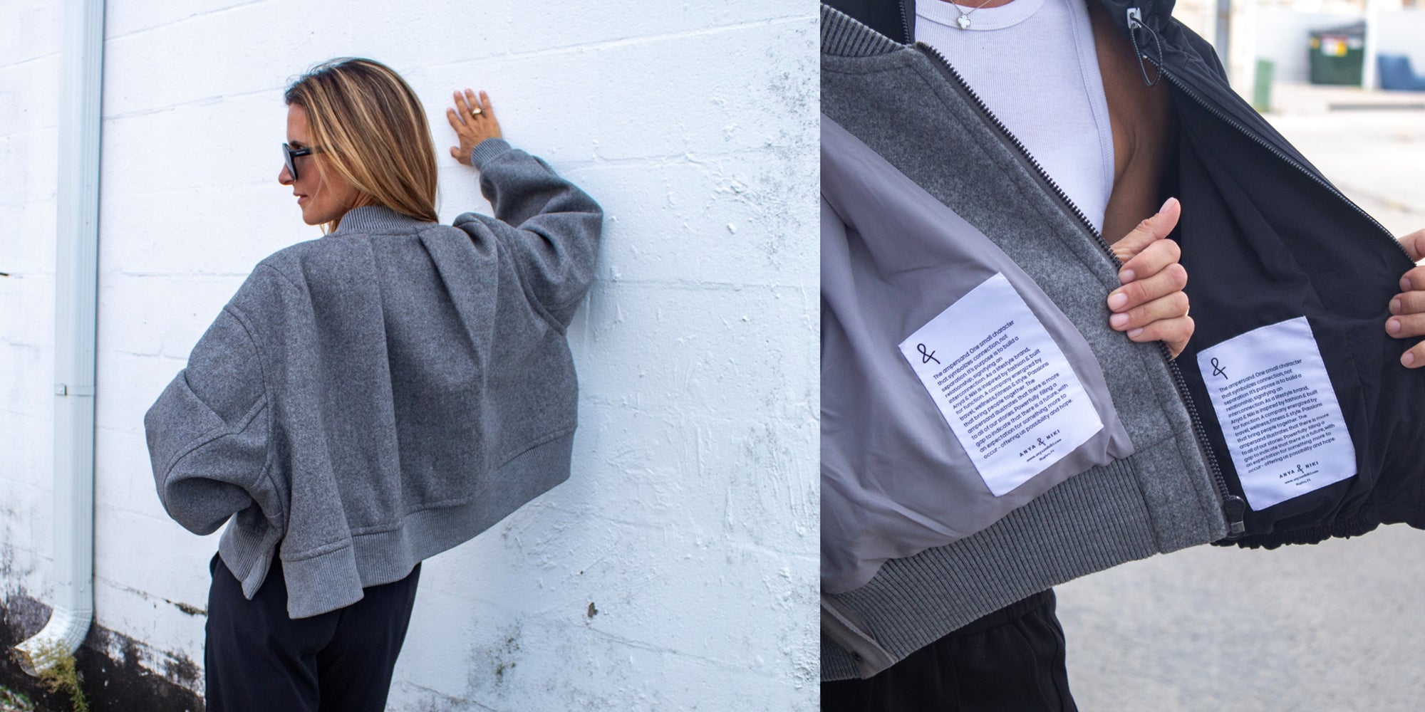 Person wearing a gray jacket with brand labels, standing against a white wall.