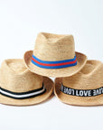 Stack of three Anya & Niki Essential straw hats with different bands. 