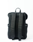 Back view of a black mesh backpack with leather details and shiny silver drawstring top.