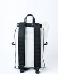 Back view of white mesh backpack with leather details and clear drawstring top.