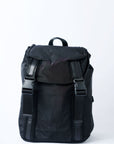 Black nylon flap top backpack with mesh and leather trim details and glossy black lining. 