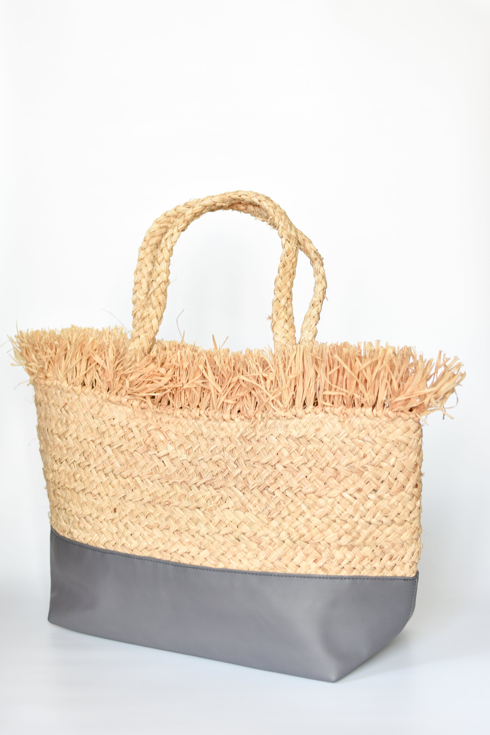 Natural raffia straw tote with linen lining and gray color block base.