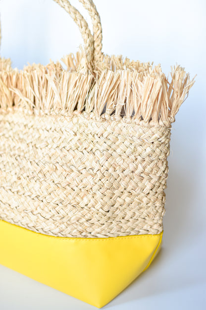 Natural raffia straw tote with linen lining and yellow color block base.