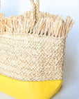 Natural raffia straw tote with linen lining and yellow color block base.